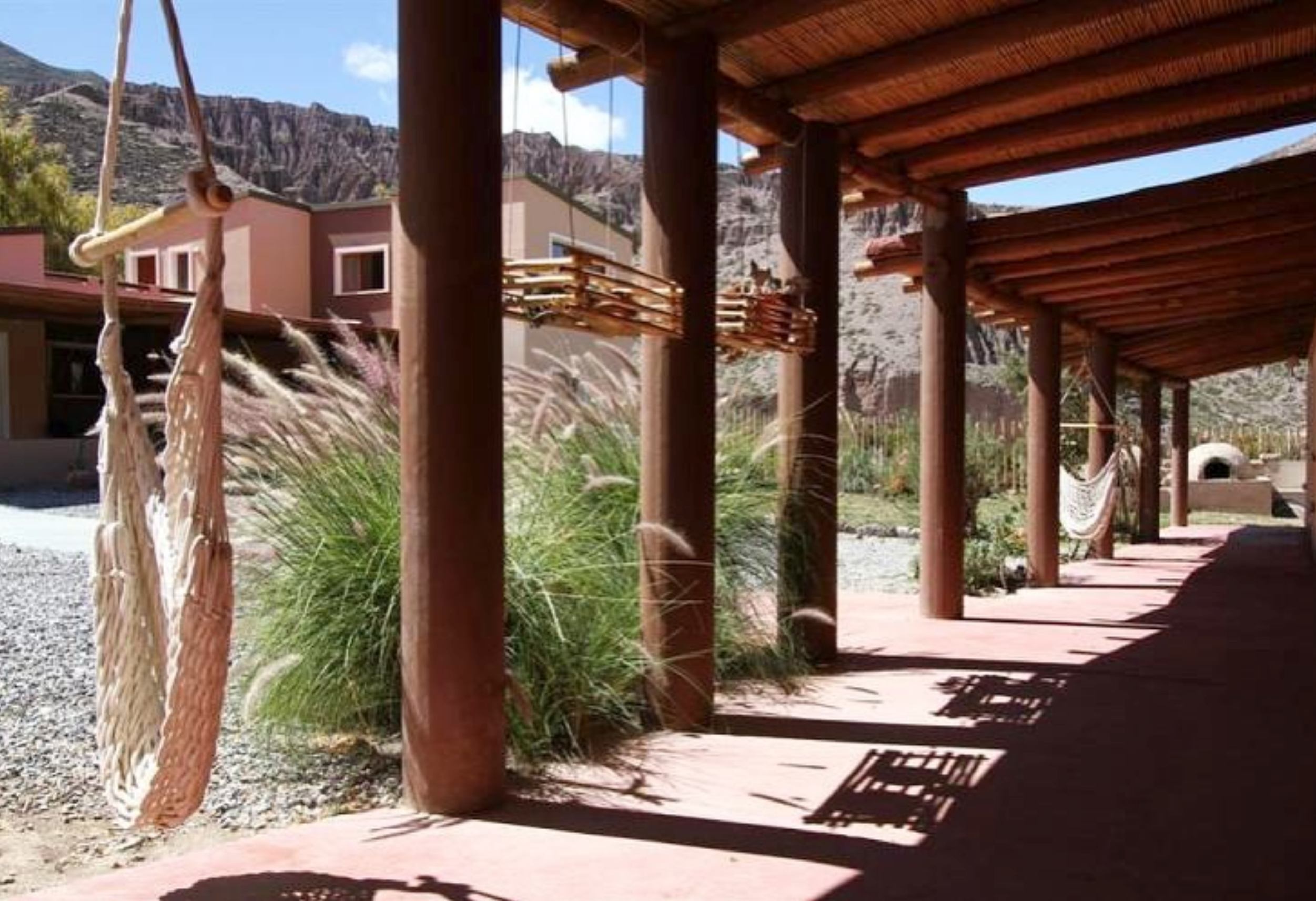 Galería con columnas de madera y hamacas paraguayas